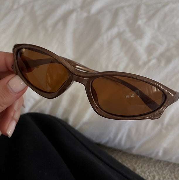 The Velocity Sunglasses in mocha, held in hand